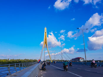 Road by bridge against blue sky