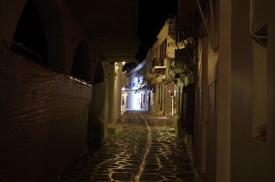 Alley amidst houses at night