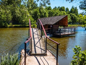 Traditional house by lake against sky