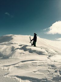 Man skiing on snowcapped mountain against sky