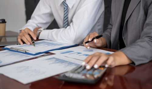 Midsection of businessman working on table