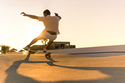 Low section of man skateboarding on road