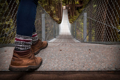 Low section of person walking on footbridge