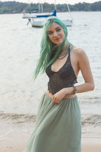 Young woman smiling while standing on beach