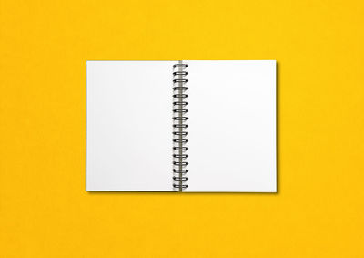 High angle view of open book against yellow background