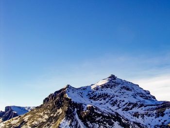 Scenic view of snowcapped mountains against clear blue sky