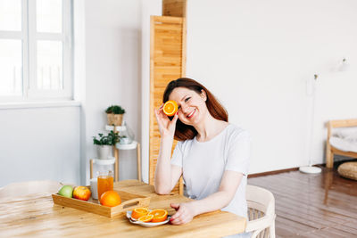 Young woman standing by glass at home