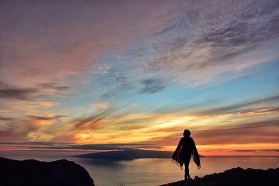 Silhouette of woman against sunset sky