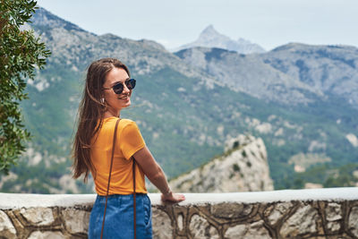 Young man wearing sunglasses standing on mountain