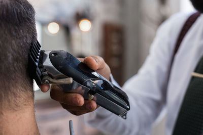 Rear view of man holding camera