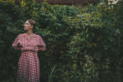 Full length of woman standing by plants