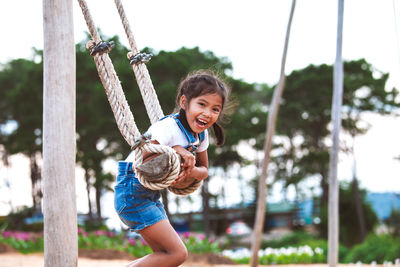 Side view of girl swinging at playground