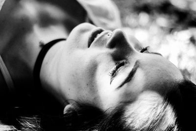 Close-up of young woman lying on field at park