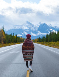 Rear view of man walking on road