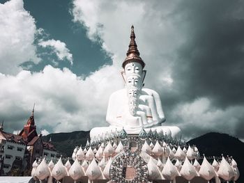 Low angle view of sculpture and building against sky