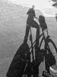 Shadow of man with bicycle on road