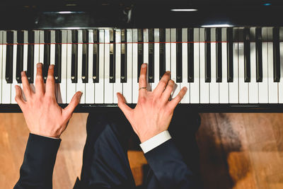 Midsection of man playing piano