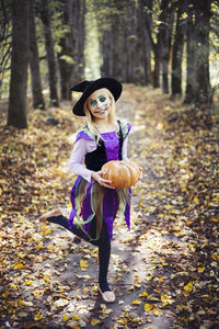 Full length of halloween girl standing in forest