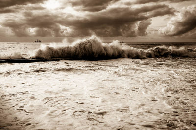 Scenic view of beach against cloudy sky