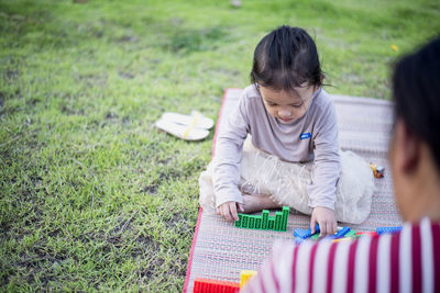 Side view of boy sitting on field