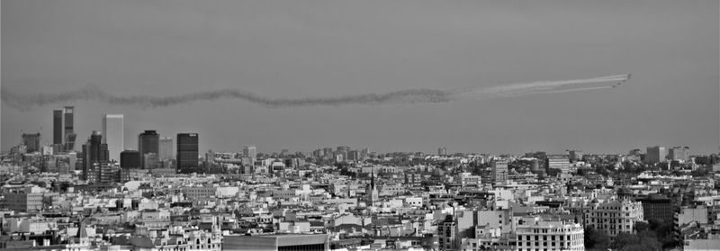 Aerial view of buildings in city against sky