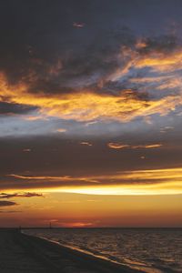 Scenic view of sea against dramatic sky during sunset