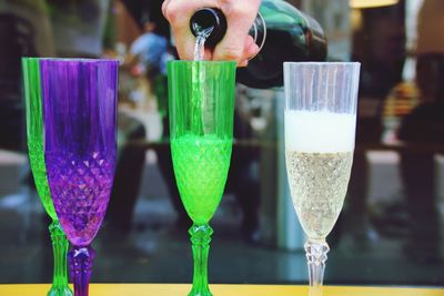 Close-up of hand pouring drink in glass