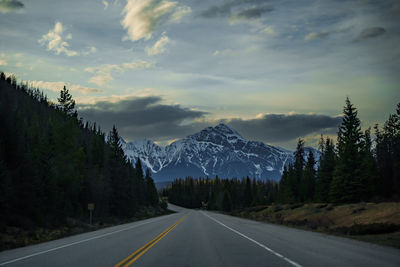 Road amidst trees against sky