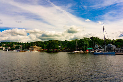 Sailboats moored in river against buildings in city