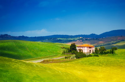 Scenic view of field and houses against sky