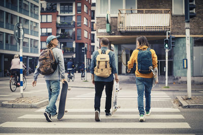 Rear view of people walking on road