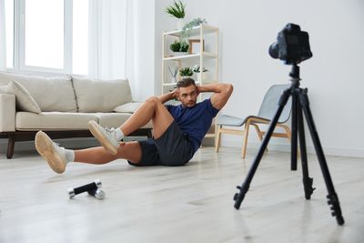 Rear view of woman sitting on bed at home