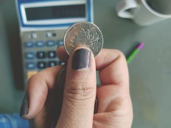 Close-up of hand holding coin