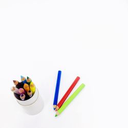 High angle view of colored pencils against white background