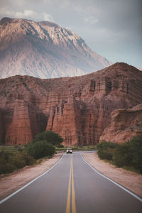 Road amidst mountains against sky