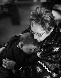 Grandmother embracing grandson while sitting at home
