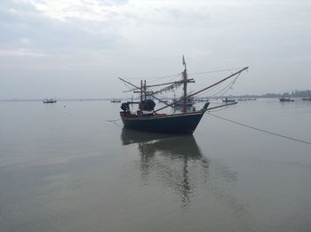 Fishing boat in sea against sky