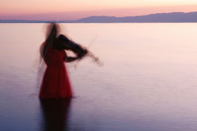 Woman with red sea against mountain