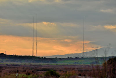 Scenic view of dramatic sky over field during sunset