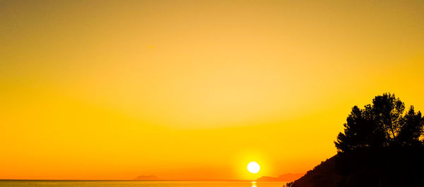 Scenic view of sea against orange sky