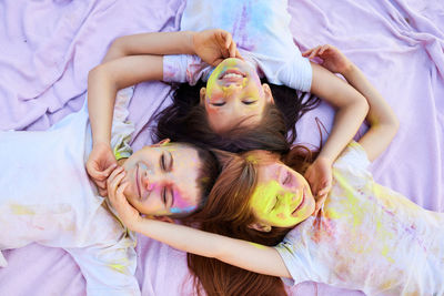 High angle view of mother and daughter lying on bed at home