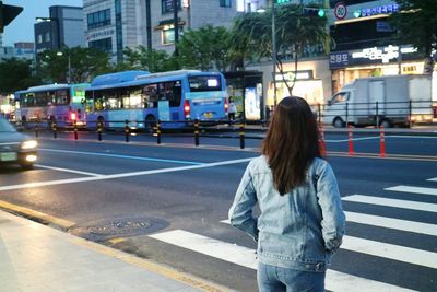 Rear view of woman crossing road