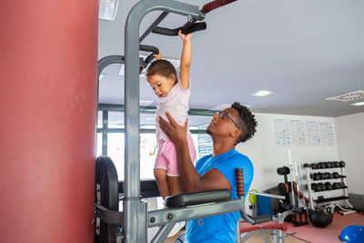 Dad teaching daughter to do pull ups