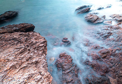 Long exposure of sea with smooth wave and rock landscape.