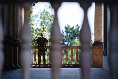 Rear view of army man standing in balcony