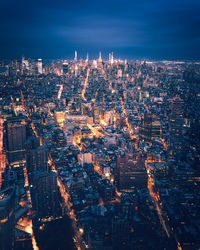 High angle view of illuminated buildings against sky at night