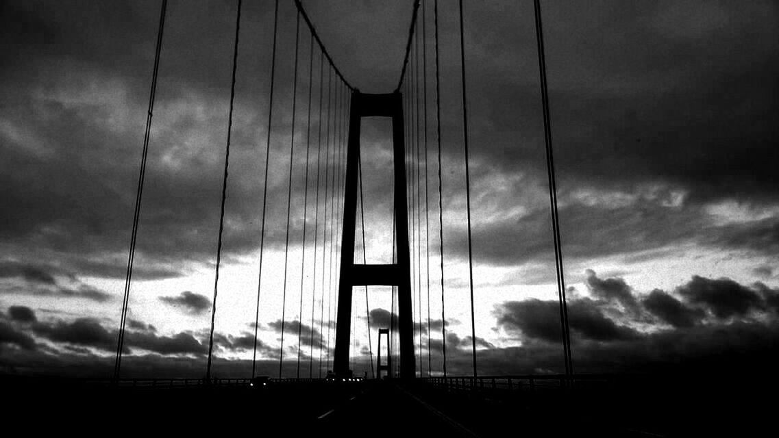 LOW ANGLE VIEW OF SUSPENSION BRIDGE AGAINST SKY AT SUNSET