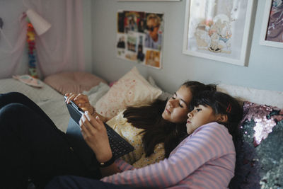 Sisters bonding over surfing internet on tablet together