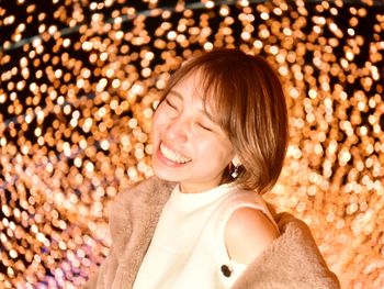 Smiling woman against illuminated lights