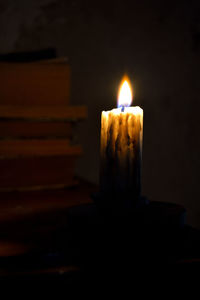 Close-up of lit candle in darkroom